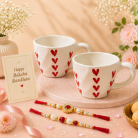 Athena Home Raksha Bandhan Gift Combo | Set of 2 Heart Print Ceramic Coffee Mugs with 2 Designer Rakhis | Festive Gift Hamper